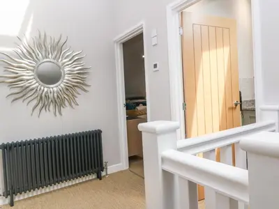 a stairway with a mirror on the wall at Postcard Lodge in Fowey