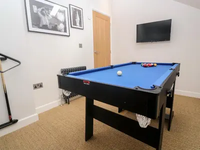 a pool table in a room with a tv at Postcard Lodge in Fowey