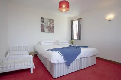 a bedroom with two beds and a red carpet at Little Close - Sea Views - Parking For 3 Cars - BBQ Area in Newquay