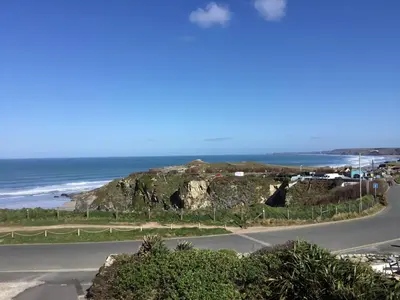 an empty road next to a beach with the ocean at Little Close - Sea Views - Parking For 3 Cars - BBQ Area in Newquay