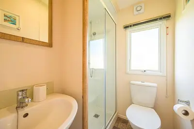 a bathroom with a sink and a toilet and a window at The Seascape, Padstow in Padstow