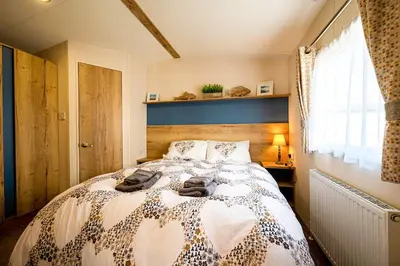 a bedroom with a large bed with towels on it at The Seascape, Padstow in Padstow