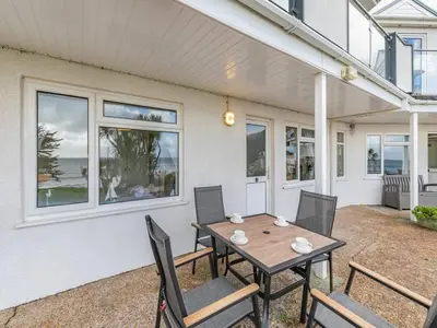 a patio with a table and chairs in front of a house at Lobster Pot - Mount Brioni in Downderry