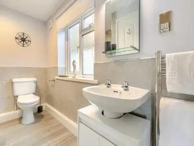 a white bathroom with a sink and a toilet at Lobster Pot - Mount Brioni in Downderry