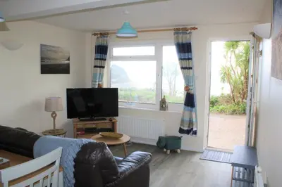a living room with a couch and a tv at Lobster Pot - Mount Brioni in Downderry