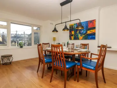 a dining room with a wooden table and chairs at Rock Pool House in Helston