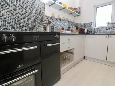 a kitchen with a black stove top oven at Rock Pool House in Helston