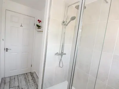 a shower with a glass door in a bathroom at Rock Pool House in Helston