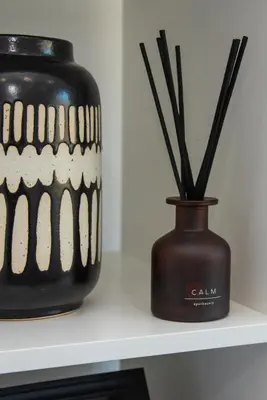two black vases with sticks in them on a shelf at Valley View Studio Annexe in Downderry