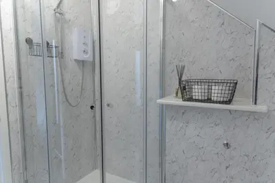 a shower in a bathroom with a glass shower stall at Valley View Studio Annexe in Downderry