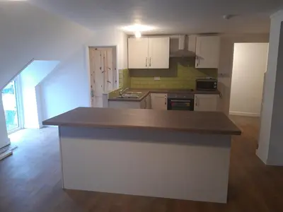 a kitchen with white cabinets and a counter top at Nice big 2 double bedroom Apartment in the Town in Newquay