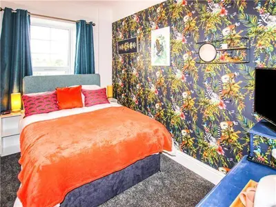 a bedroom with a bed with a colorful wallpaper at Lansdowne Simply Stay in Redruth