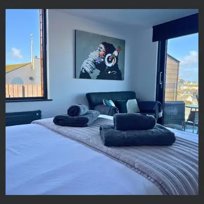 a bedroom with a large bed with pillows on it at Uno St Ives - Boutique Luxury Accommodation in St Ives