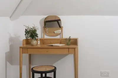 a dressing table with a mirror and two stools at Westaway House in Port Isaac