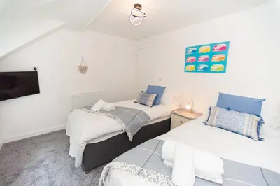 a bedroom with two beds and a flat screen tv at Modern House in Looe, Near Beach and Bars with Great Views and free access to a nearby Indoor Swimming Pool in Looe