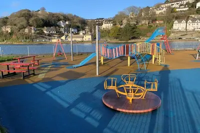 a park with a playground with a slide and tables at Modern House in Looe, Near Beach and Bars with Great Views and free access to a nearby Indoor Swimming Pool in Looe