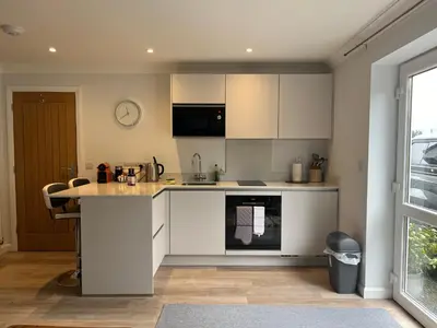 a kitchen with white cabinets and a counter top at The Hannexe in Wadebridge