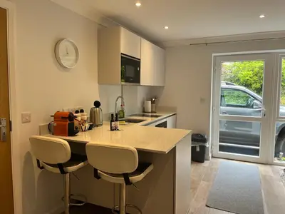 a kitchen with a counter and two stools in it at The Hannexe in Wadebridge