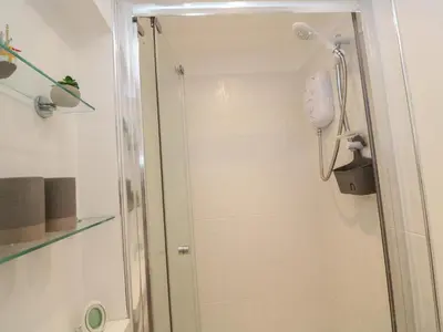 a shower with a glass door in a bathroom at Primrose Cottage in Hayle