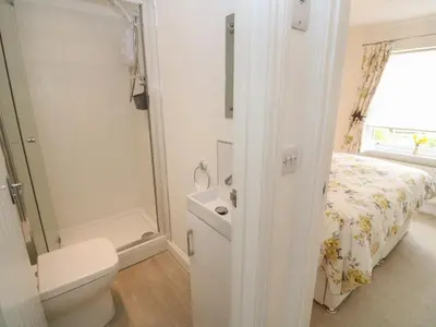 a bathroom with a toilet a sink and a shower at Primrose Cottage in Hayle