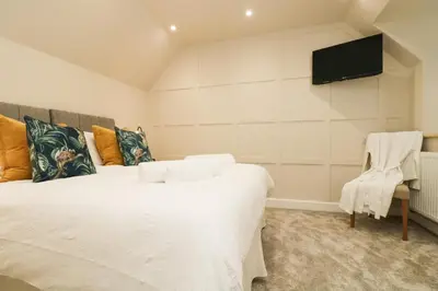 a bedroom with a bed and a tv on a wall at Robin's Nest at The Shire Inn in Camborne