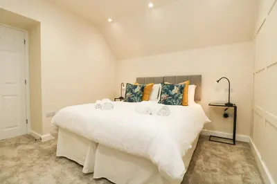 a bedroom with a large white bed with towels on it at Robin's Nest at The Shire Inn in Camborne