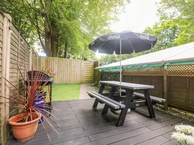 a patio with a picnic table and an umbrella at Robin's Nest at The Shire Inn in Camborne