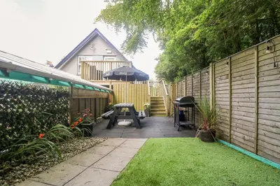 a backyard with a table and an umbrella at Robin's Nest at The Shire Inn in Camborne