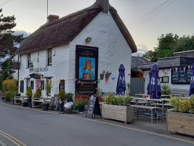 a white building with a thatched roof at Wish You Were Here - Hot Tub - Free Parking & Free WiFi in Newquay