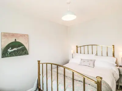 a bedroom with a bed and a crib at Honeycroft in Boscastle