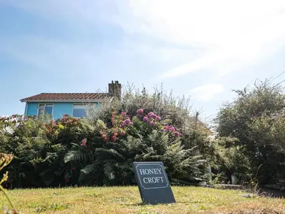 a house guest sign in front of a flower garden at Honeycroft in Boscastle