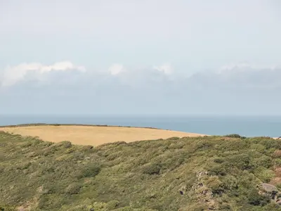 a view of a hill with mountains in the background at Honeycroft in Boscastle
