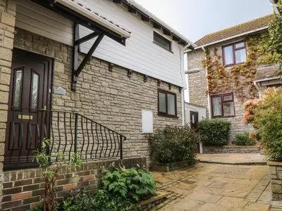 a brick house with a black door and a courtyard at 12 Claremont Falls in Looe
