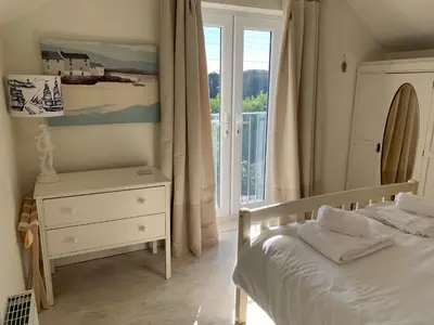 a bedroom with a bed and a window at Little Karenza is the perfect Cornish getaway in Saint Anthony