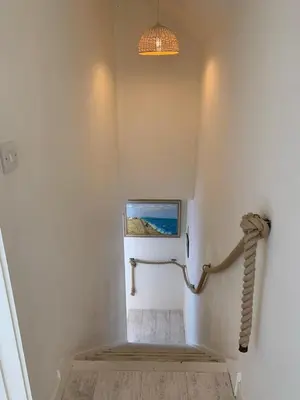 a staircase in a house with a light at Little Karenza is the perfect Cornish getaway in Saint Anthony