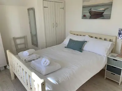 a bedroom with a bed with towels on it at Little Karenza is the perfect Cornish getaway in Saint Anthony