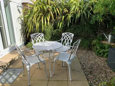 a white table and four chairs on a patio at Little Karenza is the perfect Cornish getaway in Saint Anthony