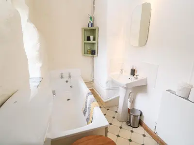 a white bathroom with a tub and a sink at Porth Farm Annexe in Newquay