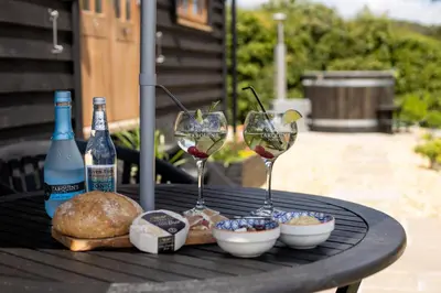 two glasses of wine and bread on a table at Daisy Park Shepherds Hut in Looe