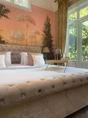 a large bed in a bedroom with pink walls at Penarwyn House in Par