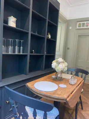 a dining room with a wooden table and two blue chairs at Penarwyn House in Par