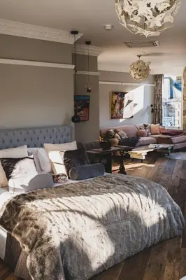 a bedroom with a large bed and a couch at Host St Ives in St Ives