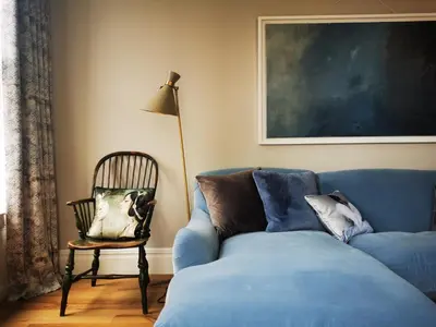 a living room with a blue couch and a chair at Host St Ives in St Ives