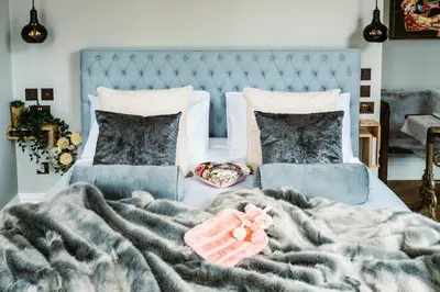 a bedroom with a blue bed with a blanket and pillows at Host St Ives in St Ives