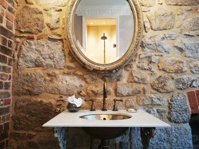 a stone bathroom with a sink and a mirror at Host St Ives in St Ives