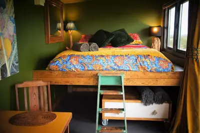 a bedroom with a bed with a ladder next to it at The Bolt Hole in St Merryn