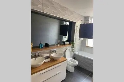 a bathroom with two sinks and a toilet and a tub at Central, stylish 3 bed apartment with sea views in Newquay