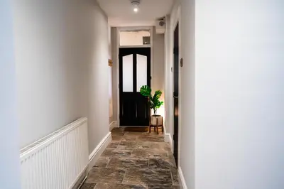 a hallway with a black door and a potted plant at Central, stylish 3 bed apartment with sea views in Newquay