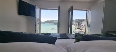 a room with two beds and a view of the ocean at Chy Mor Apartment 2 - Stunning sea views on the harbour in St Ives