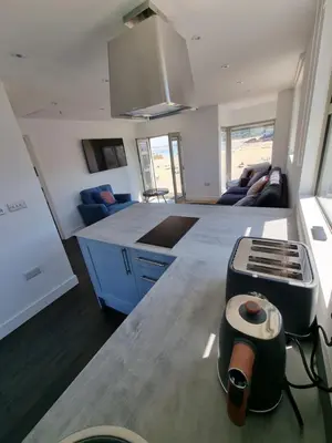 a kitchen and living room with a stove in it at Chy Mor Apartment 2 - Stunning sea views on the harbour in St Ives